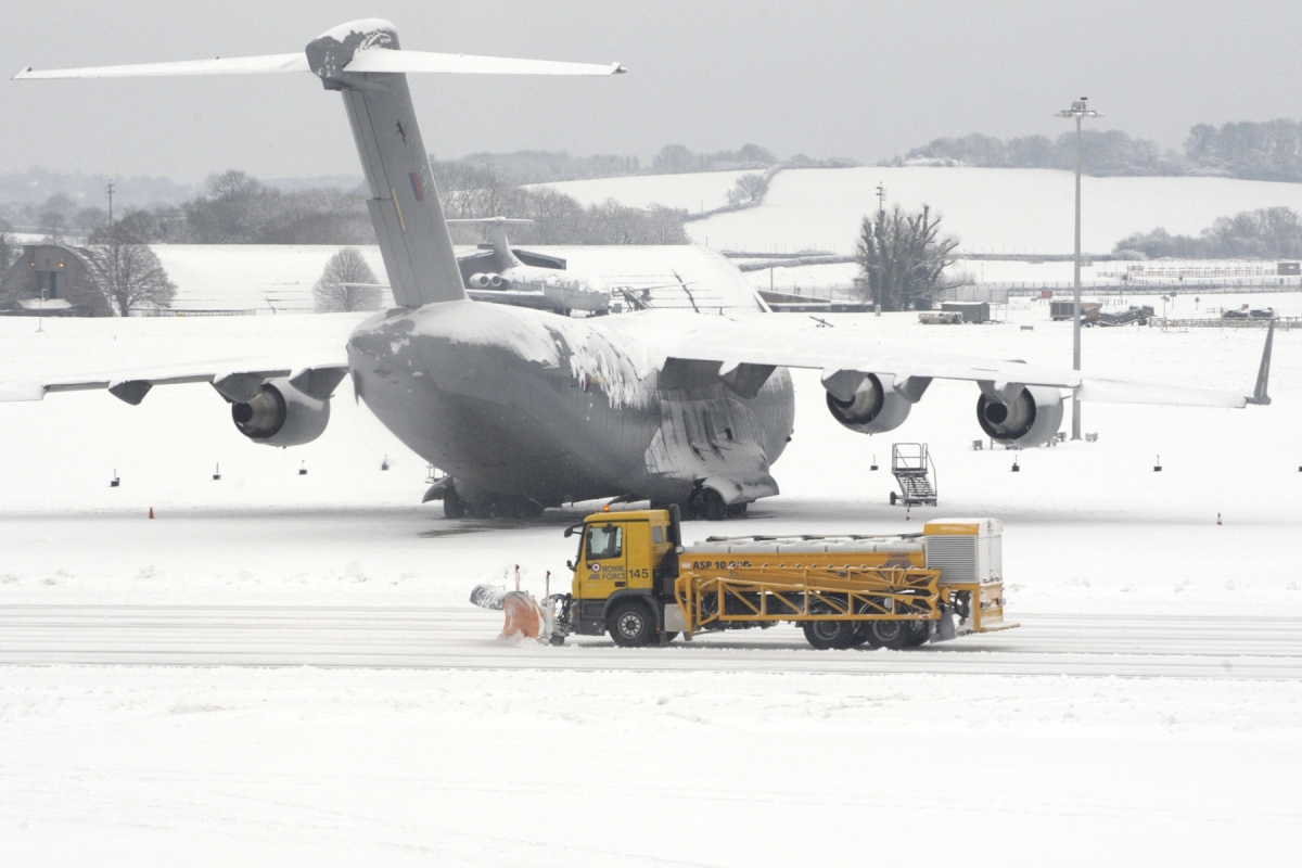 An airfield support snow clearance vehicle passing behind a Royal Air Force Boeing C-17A Globemaster III aircraft, of No. 99 Squadron, RAF Brize Norton. Jan 2010, Source: wikicommons. Author: RAF Brize Norton Photographic Section